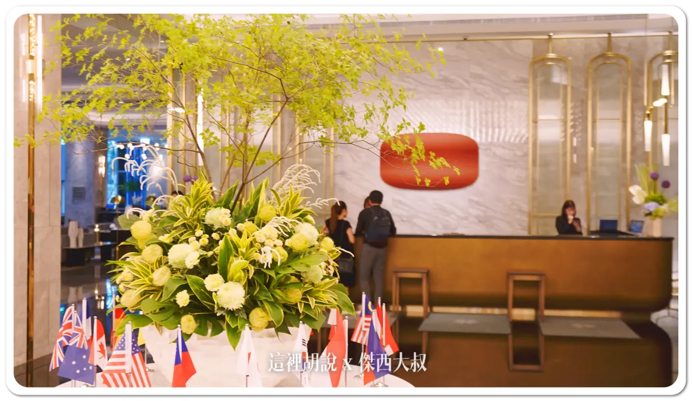 The hotel's lobby is pretty eye-catching. Right in the middle, there's this huge flower arrangement. Around it, they've set up flags from different countries to welcome international guests. It's a nice touch that gives the place a really welcoming, global vibe.