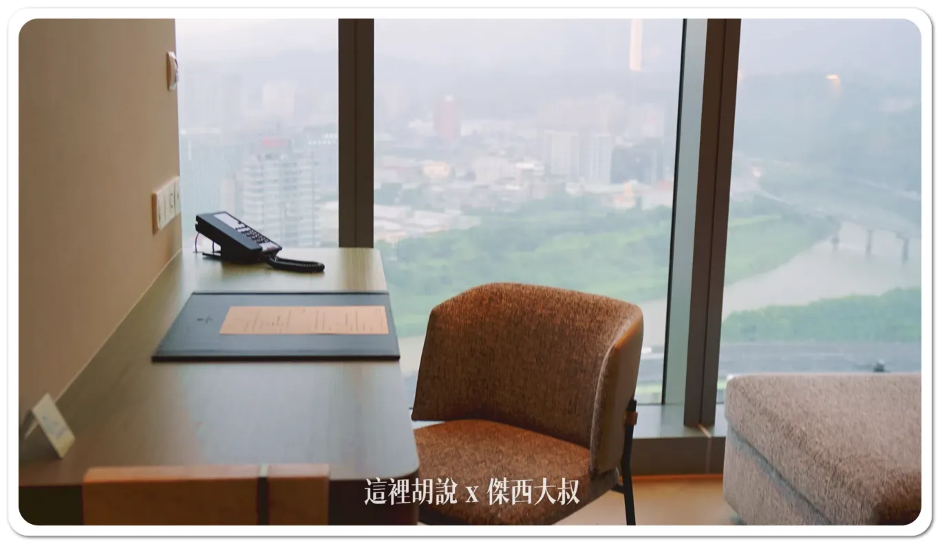 The desk is set up next to the floor-to-ceiling window and sofa, giving you plenty of space to work.