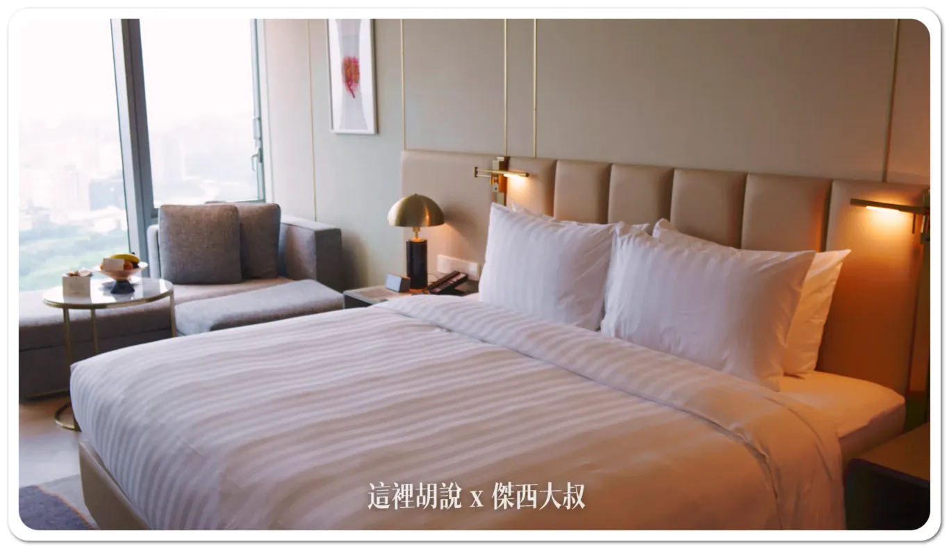 整體房間空間主要使用木質地板，床鋪周圍的下床區域則有鋪上地毯。
