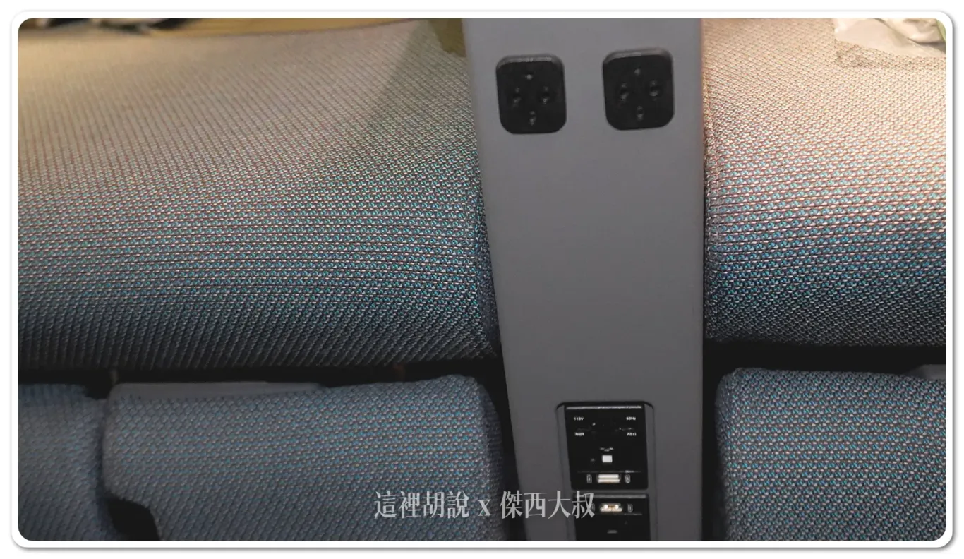 Another charging location is situated in front of the armrest. Above it is the headphone jack, while below is the charging area, offering passengers easy access to power for their devices during the flight.