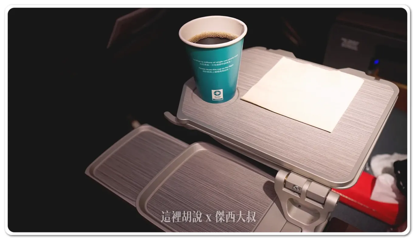 In addition to the tray table built into the seat, there are extra cup holder spaces located on the central armrest and in the space in front of the armrest. These holders provide convenient places to store drinks, ensuring that passengers have easy access to beverages without cluttering their immediate area. This thoughtful design helps keep the seating area organized and adds to the overall comfort during the flight.