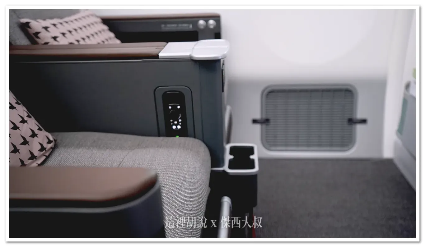 The water bottle holder for the first-row Premium Economy Class seat, located at seat 20AC.