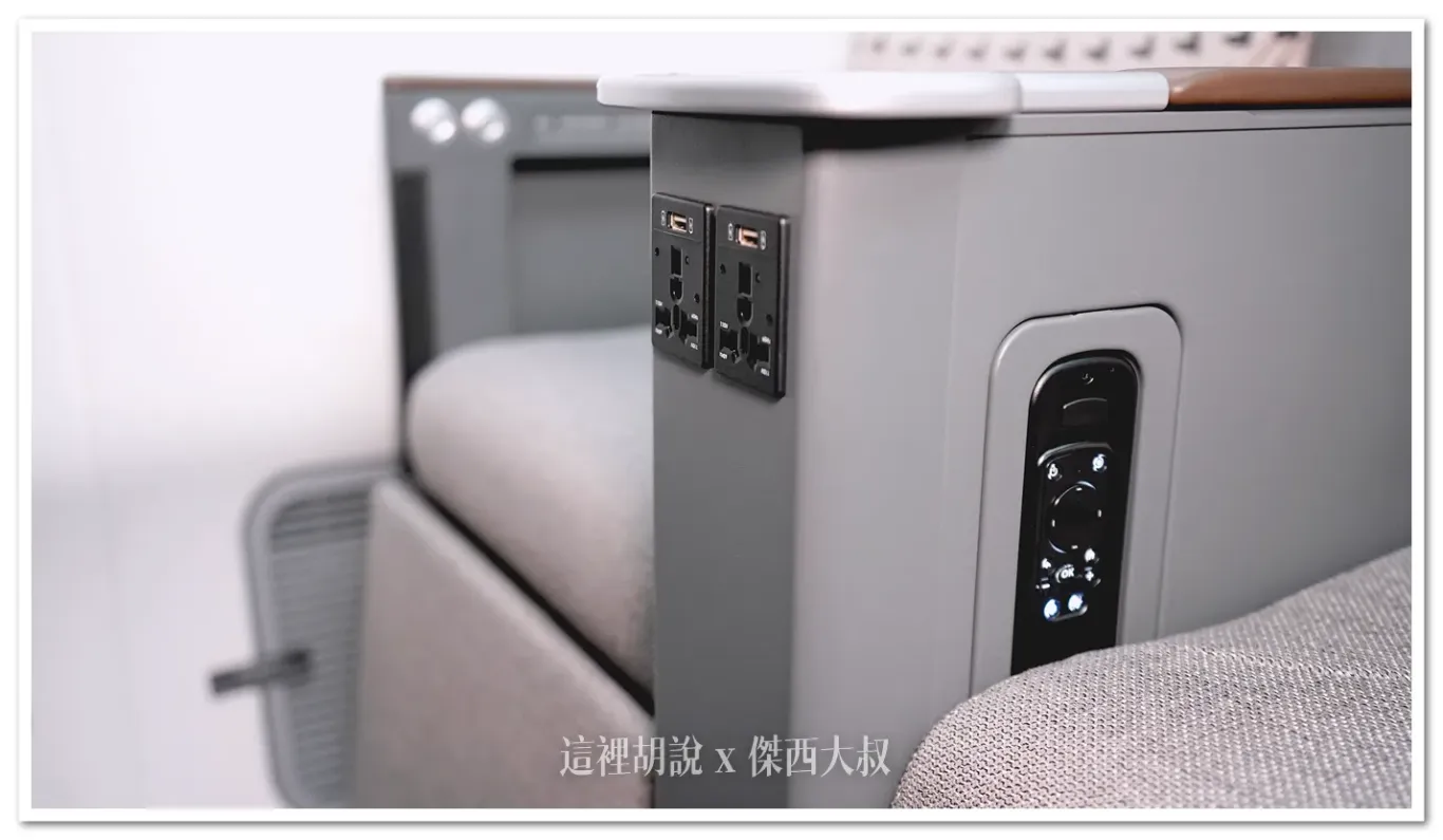 Below the center armrest, there is a universal power outlet and a USB Type-A charging port.