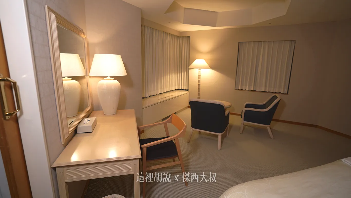 The master bedroom has two beds, a desk, and a coffee table.