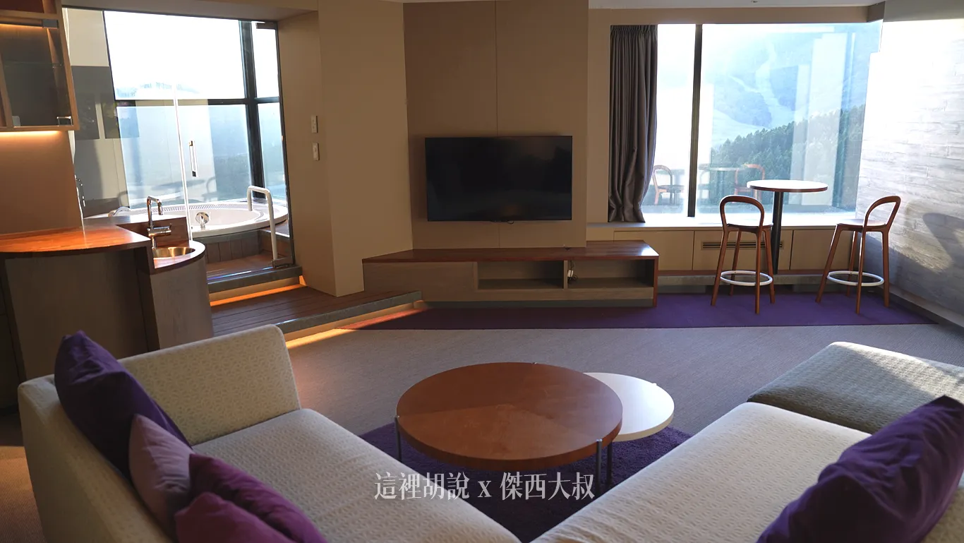 The living area has a small sink, and the sofa has been replaced with a modern L-shaped sofa.