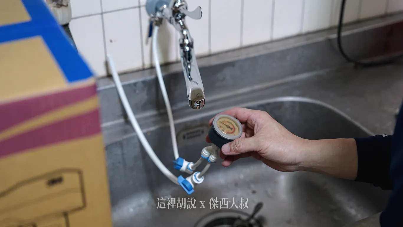 首先先進行三通的安裝，安裝的時候，安裝師傅也會檢查水壓（圖片當中為師傅帶來檢測用的水壓表），水壓太高或者太低都不好，安裝人員都會提醒注意，像是傑西老家廚房的水壓經過檢查壓力偏低，需要額外加裝加壓馬達來解決問題。