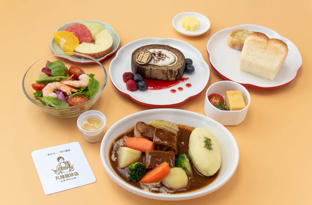 華航與大阪老字號喫茶店「丸福珈琲店」合作推出商務艙套餐，包含前菜、沙拉、主菜雙選項、麵包及甜點，皆是融合多種元素設計而成的和風洋食。