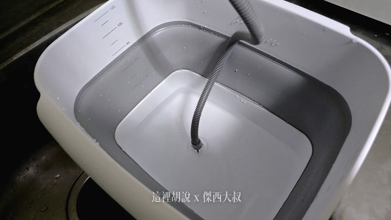 洗碗機專用的白色折疊抽水盆放置在洗手槽中,內側標有容量刻度並注滿清水,灰色吸水軟管垂直延伸至盆底進行供水。洗水頭固定在底座,可以完整抽出所有清水 洗碗機專用的白色折疊抽水盆放置在洗手槽中,內側標有容量刻度並注滿清水,灰色吸水軟管垂直延伸至盆底進行供水。洗水頭固定在底座,可以完整抽出所有清水