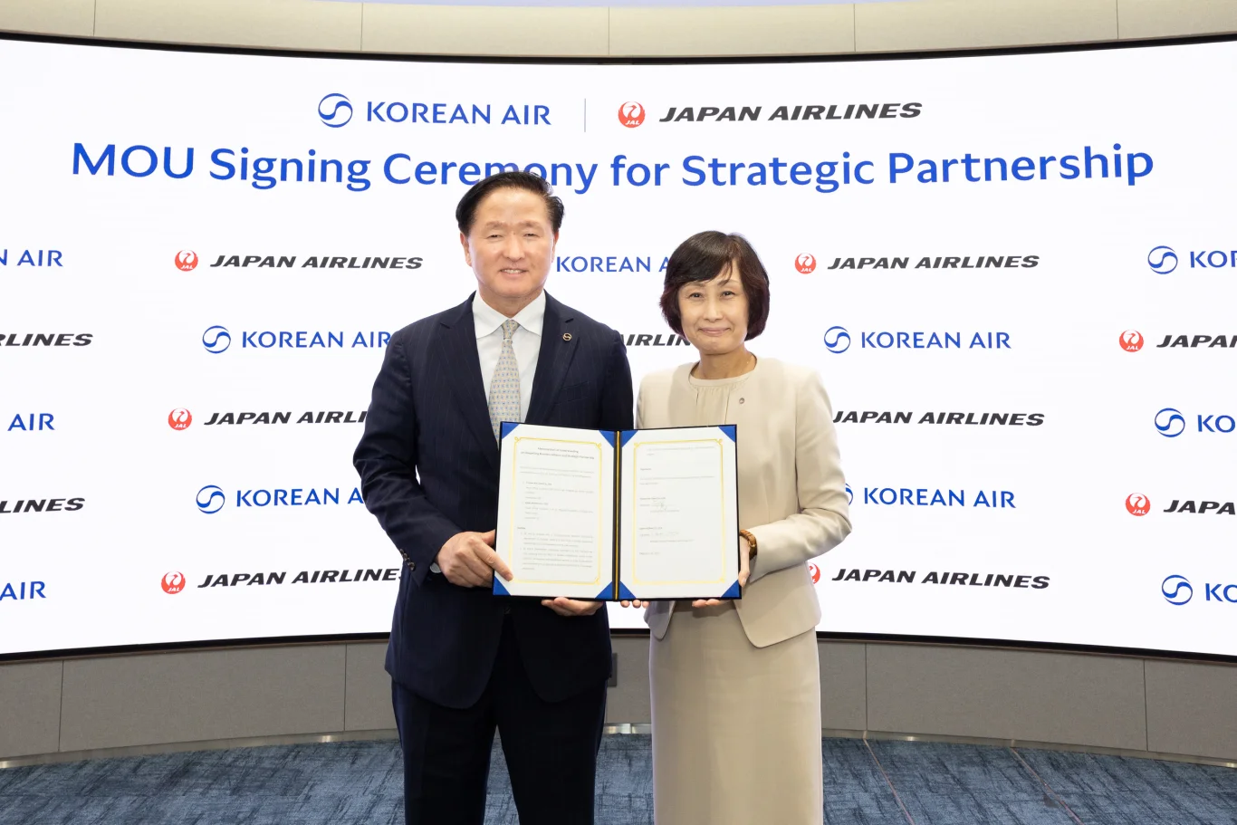 在戰略合作備忘錄（MOU）簽署儀式上。左：大韓航空副會長 禹基洪 (Keehong Woo)，右：日本航空社長 鳥取三津子 (Mitsuko Tottori)。