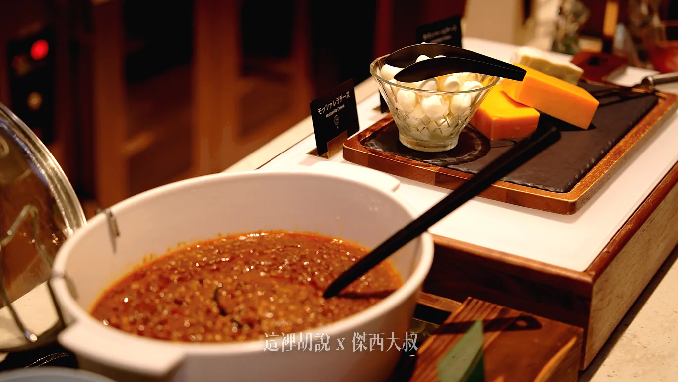 冷盤區陳列著盛裝濃郁肉醬的白色陶瓷深鍋，後方木托盤上則擺放著玻璃碗裝的小顆莫札瑞拉起司球與切塊的黃色起司磚供取用