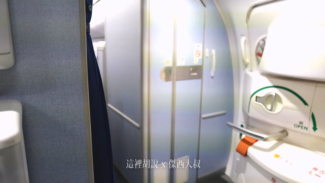 最後一排旁邊的廁所，門開口是面對緊急出口