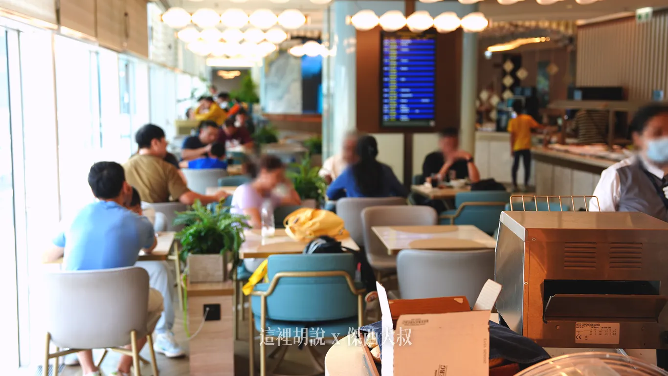 香港機場KYRA貴賓室的用餐空間多採餐桌形式,採光明亮的大片窗邊整齊排列著藍灰色座椅與雙人方桌,上方懸掛圓形燈飾,後方柱面則設有航班資訊螢幕。 香港機場KYRA貴賓室的用餐空間多採餐桌形式,採光明亮的大片窗邊整齊排列著藍灰色座椅與雙人方桌,上方懸掛圓形燈飾,後方柱面則設有航班資訊螢幕。