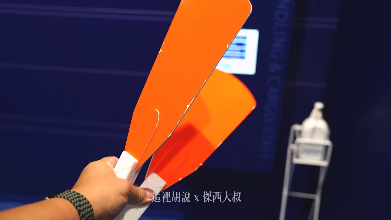 亮橘色扁平葉片的指示牌，這項器材是地勤人員在停機坪引導航機滑行方向時所使用的工具。